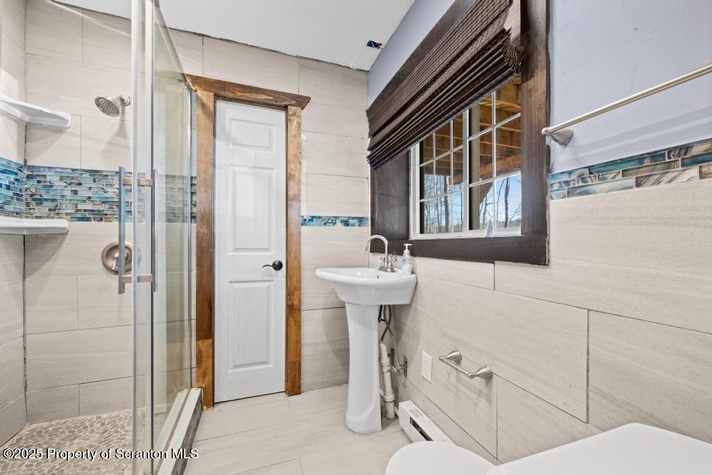 3110 Cherry Ridge Road Bushkill, PA 18324 - Photo 40 of 61 a bathroom with a sink and mirror with bathtub