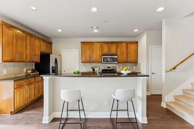 a kitchen with stainless steel appliances granite countertop white cabinets a sink and a stove