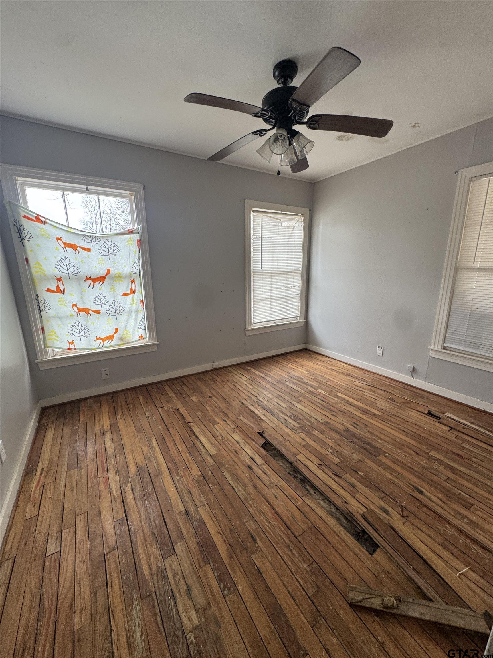 wooden floor in an empty room with a window