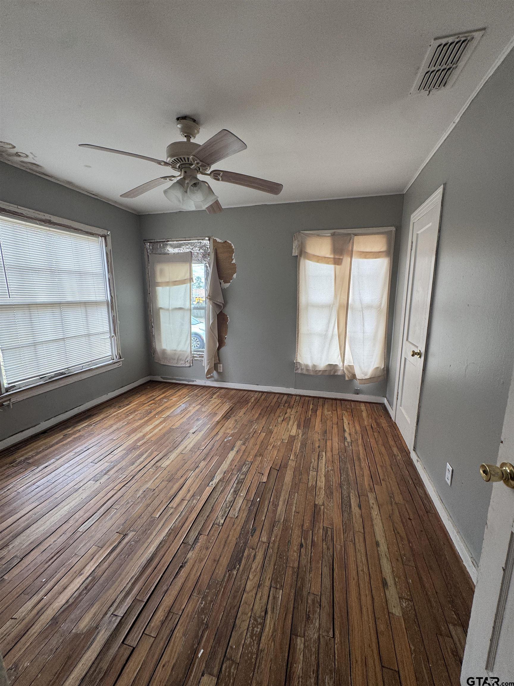 2927 New Copeland Road Tyler, TX 75701 - Photo 3 of 12 wooden floor in an empty room with a window