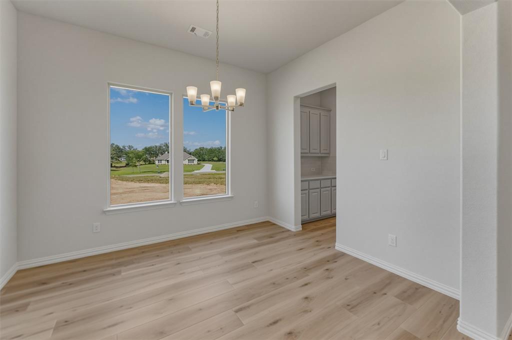 605 Tay Tay Way Springtown, TX 76082 - Photo 9 of 31 Spacious room featuring wood-finish flooring, light gray walls, and white trim