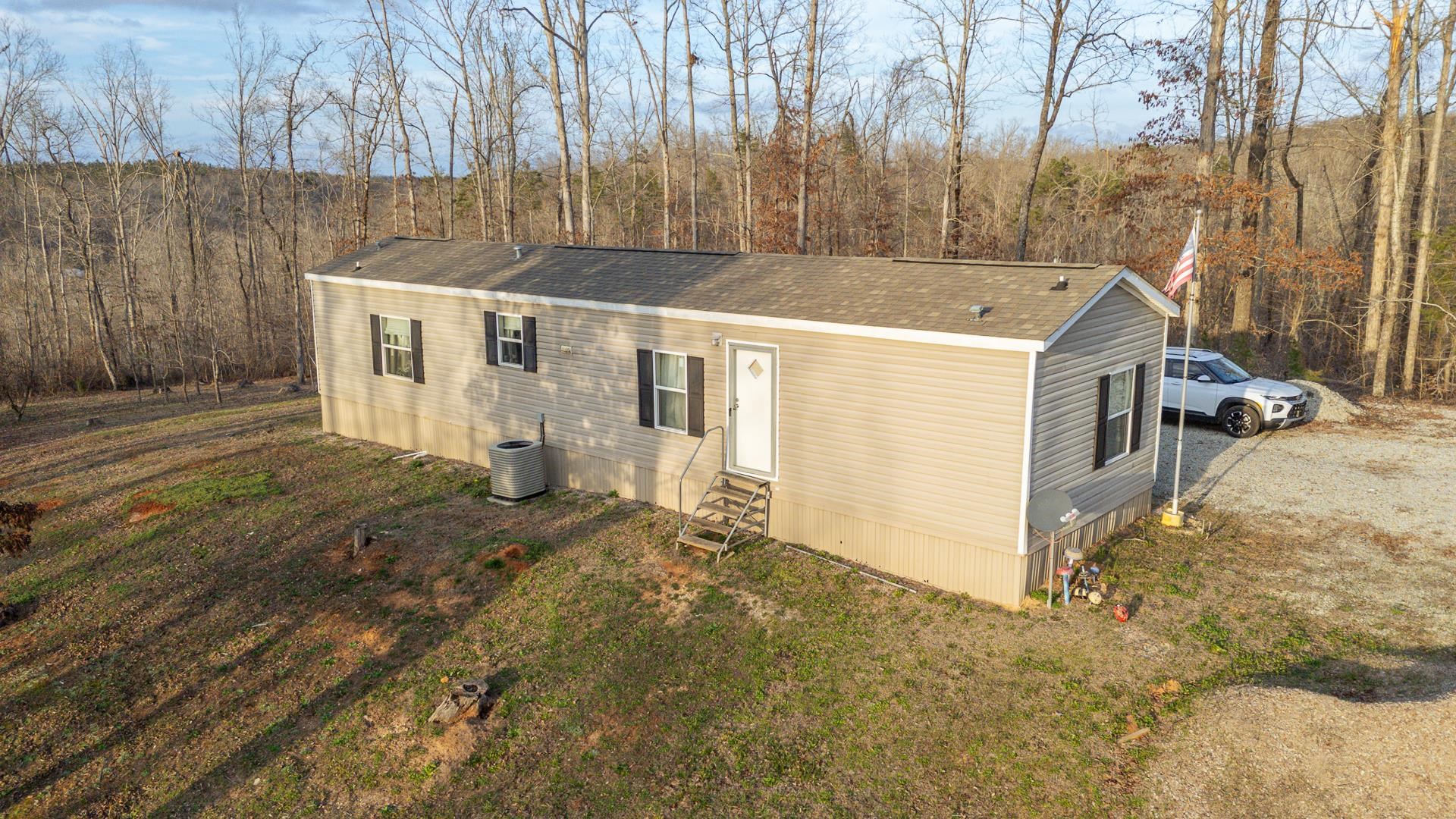 125 Elam Way Savannah, TN 38372 - Photo 36 of 36 View of front of home with entry steps, a shingled roof, and a wooded view