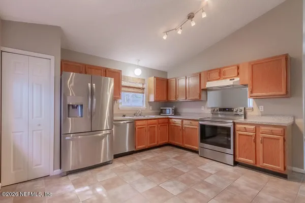 a kitchen with stainless steel appliances granite countertop a refrigerator sink and stove
