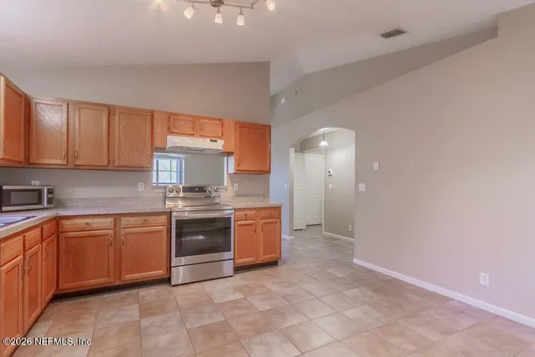 a large kitchen with stainless steel appliances granite countertop a stove and a sink