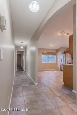 a view of an empty room and a kitchen