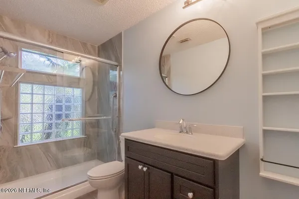 a bathroom with a sink a mirror a toilet and shower