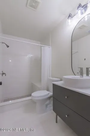 a bathroom with a sink a toilet and shower
