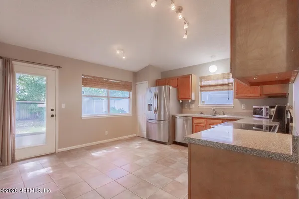 a kitchen with stainless steel appliances granite countertop a refrigerator a sink a stove and oven