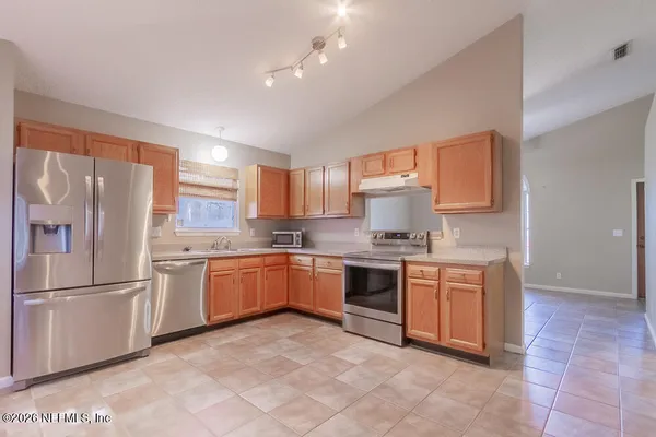 a kitchen with stainless steel appliances granite countertop a refrigerator sink and stove