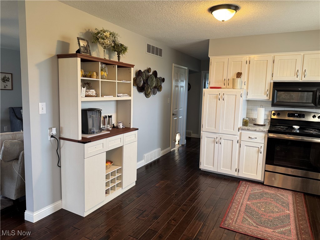 1790 Rix Mills Road New Concord, OH 43762 - Photo 13 of 28 Kitchen featuring visible vents, black microwave, open shelves, and electric stove