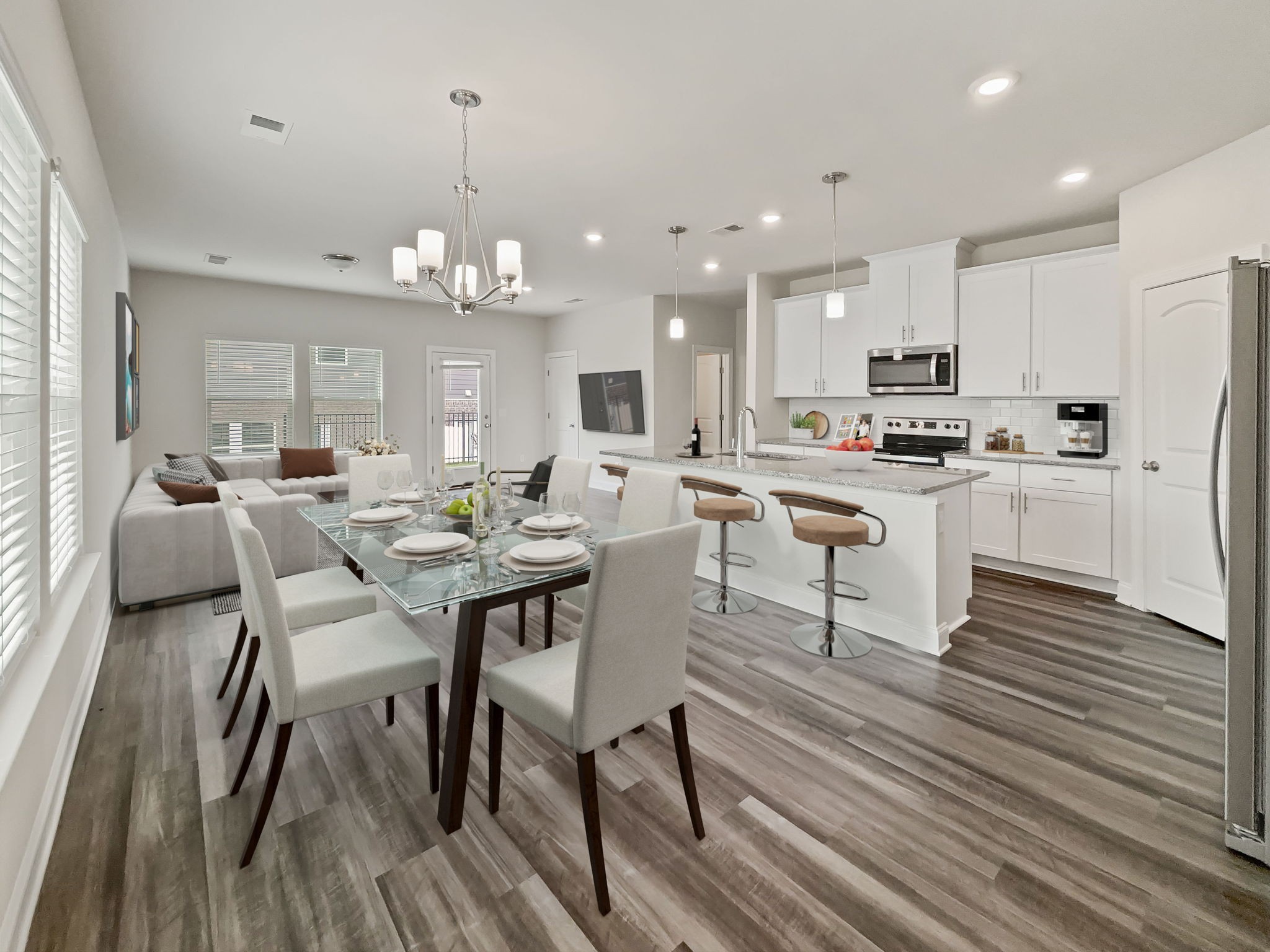 a large kitchen with cabinets wooden floor white stainless steel appliances and dining table