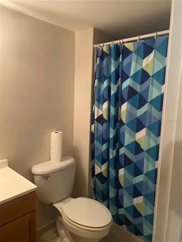 a white toilet sitting next to a shower curtain
