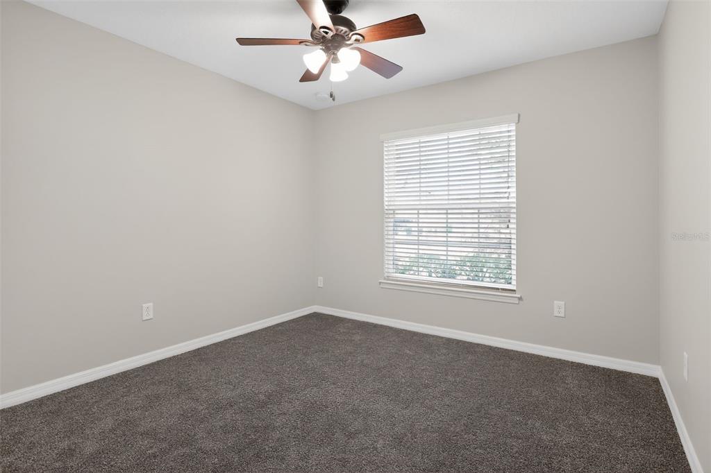 46 Sea Trail Palm Coast, FL 32164 - Photo 16 of 21 an empty room with a window and a fan