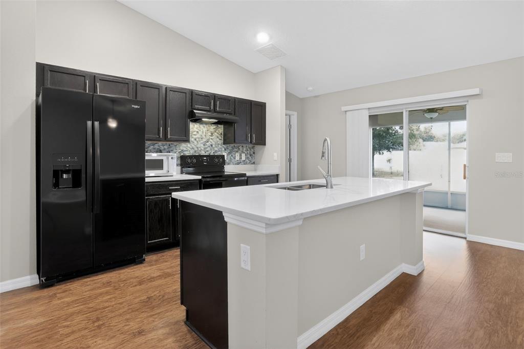 46 Sea Trail Palm Coast, FL 32164 - Photo 4 of 21 a kitchen with stainless steel appliances a sink a stove a refrigerator and cabinets