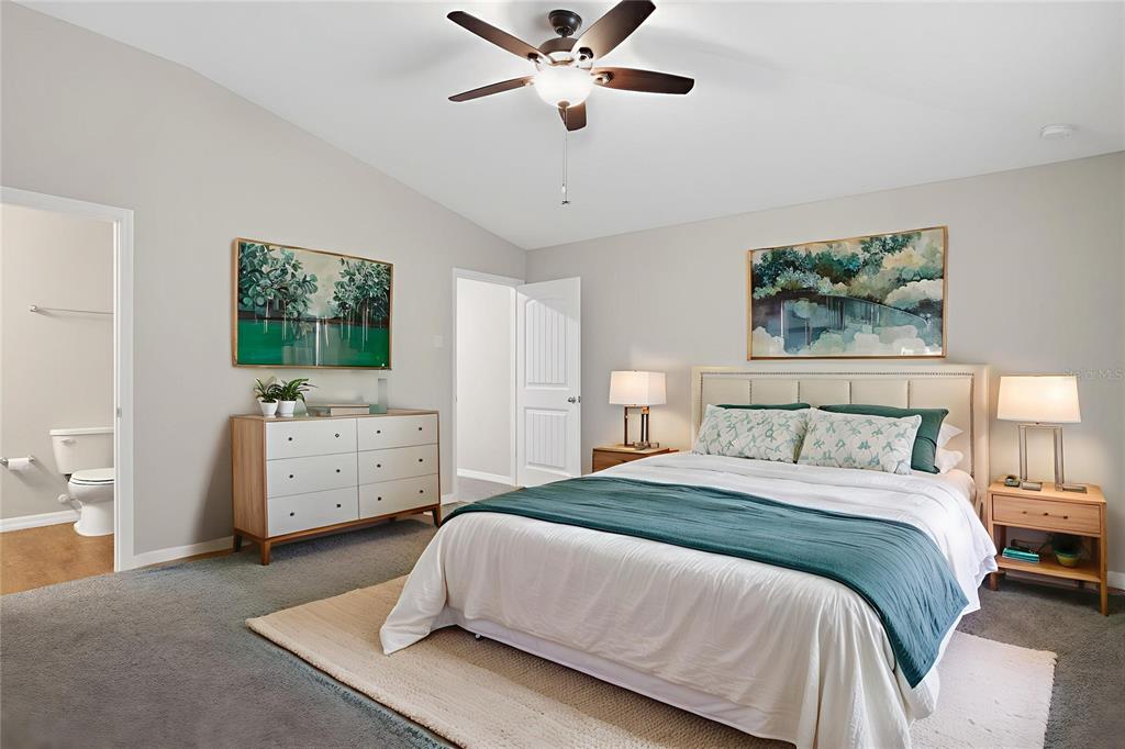 46 Sea Trail Palm Coast, FL 32164 - Photo 10 of 21 a spacious bedroom with a bed and a chandelier