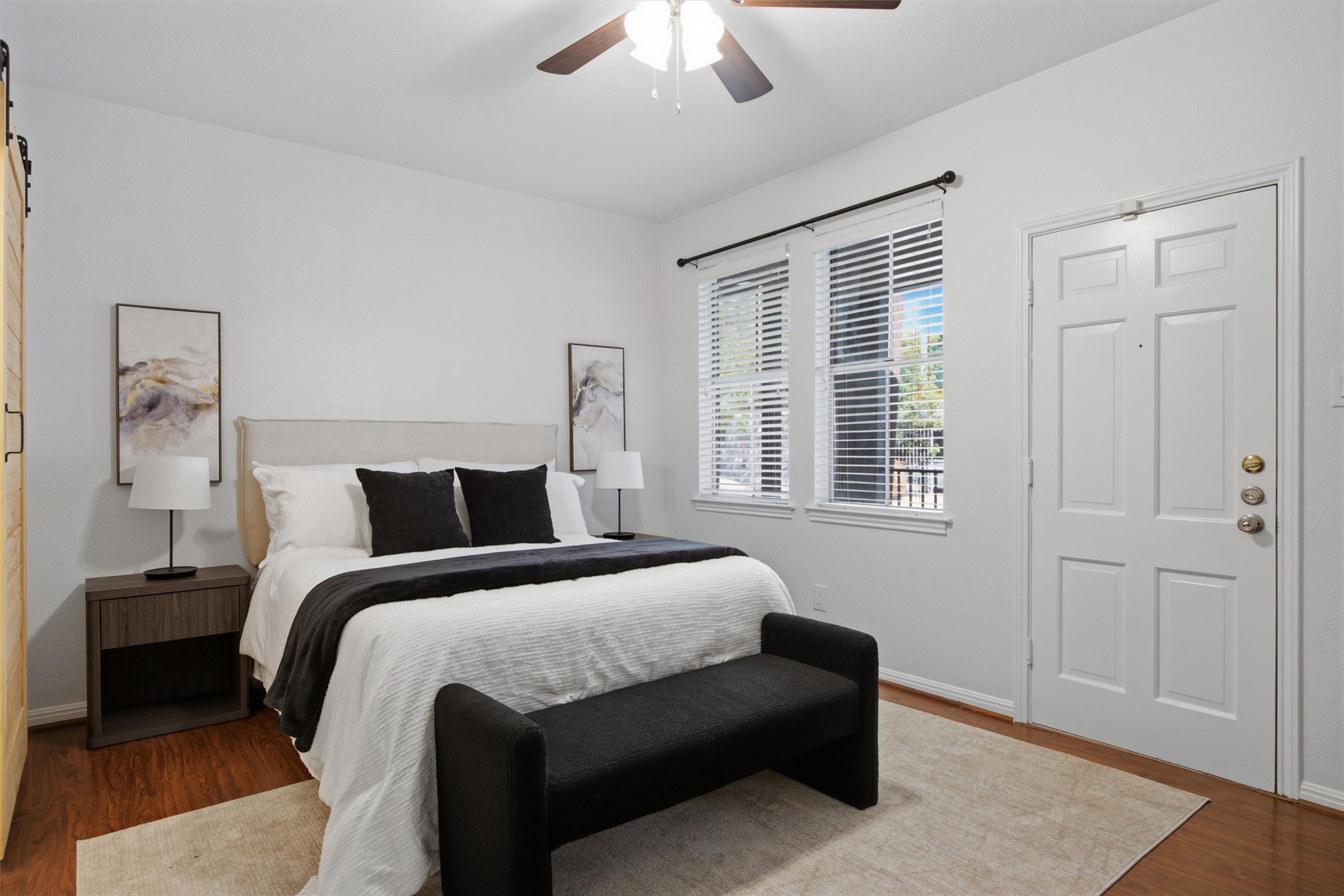 2529 Rio Grande Street, Unit 72 Austin, TX 78705 - Photo 14 of 24 Warm wood flooring and natural light define the primary bedroom.