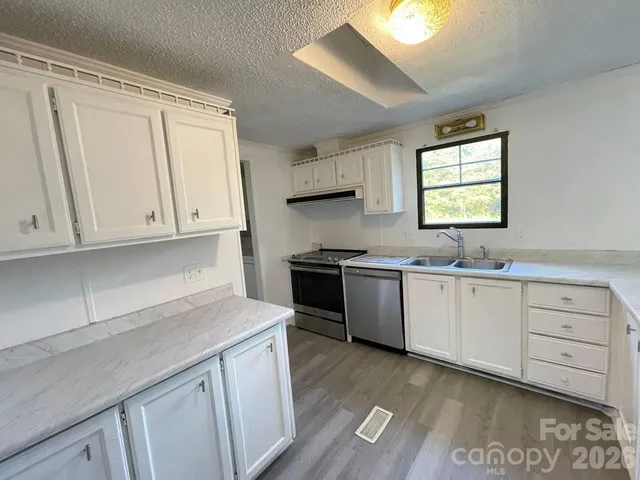 a kitchen with granite countertop white cabinets and white appliances