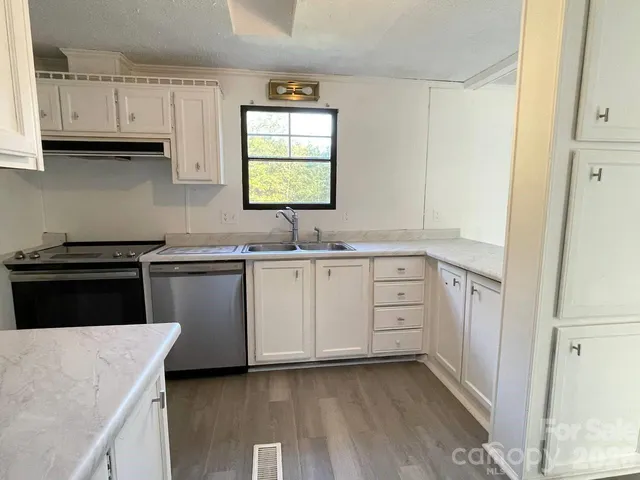a kitchen with cabinets appliances a sink and a window
