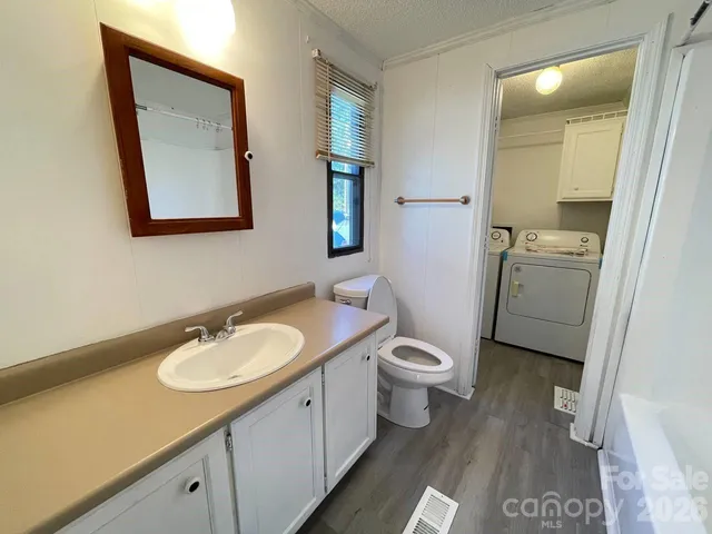 a bathroom with a toilet sink double vanity and mirror