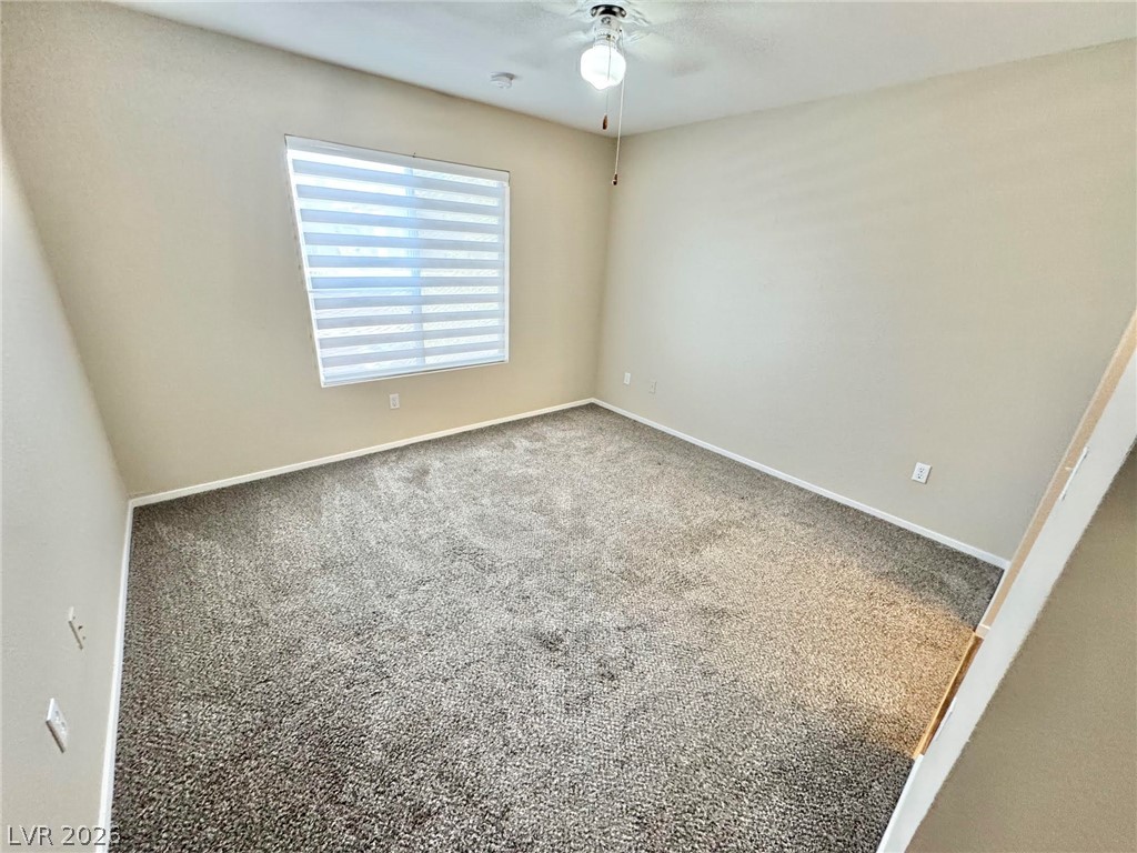 8070 West Russell Road, Unit 2121 Las Vegas, NV 89113 - Photo 12 of 22 An airy bedroom with carpeted floors and a window, ideal for restful living.