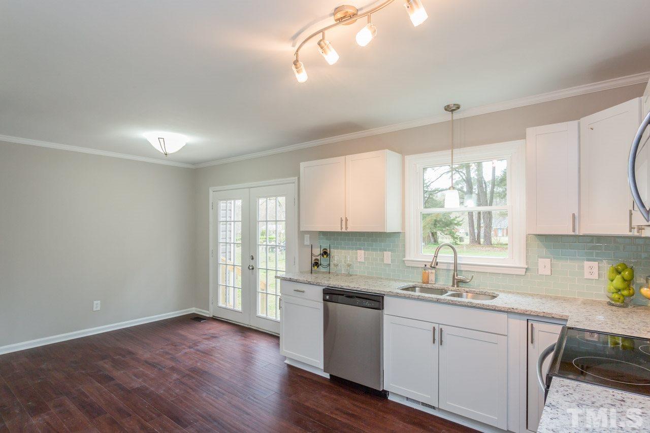 3822 Corwin Road Garner, NC 27529 - Photo 2 of 25 a kitchen with a sink cabinets stainless steel appliances and windows