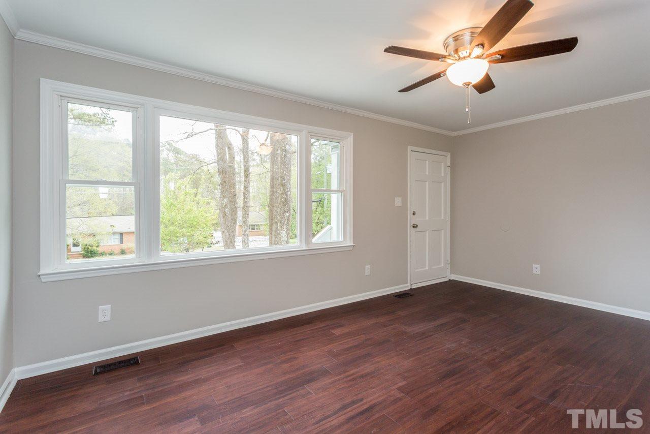 3822 Corwin Road Garner, NC 27529 - Photo 3 of 25 a view of an empty room with wooden floor and a window