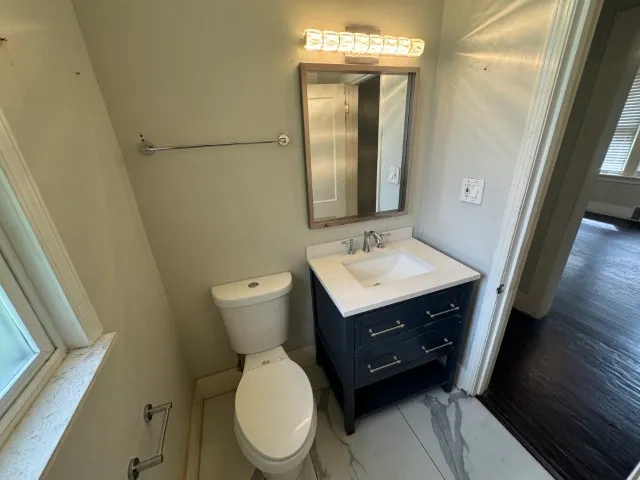 a bathroom with a toilet a sink and mirror