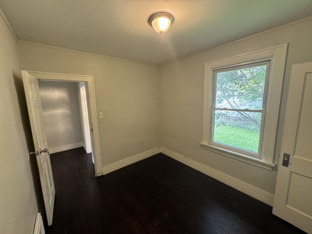 10117 South Perry Avenue Chicago, IL 60628 - Photo 15 of 33 an empty room with wooden floor and windows