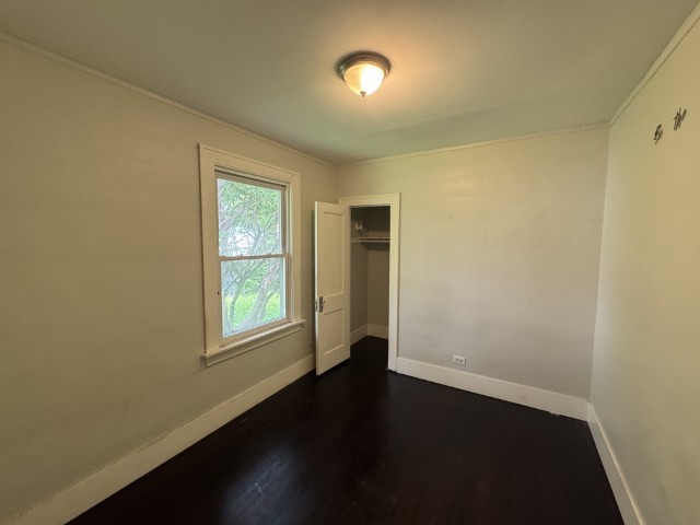 10117 South Perry Avenue Chicago, IL 60628 - Photo 16 of 33 an empty room with wooden floor and windows