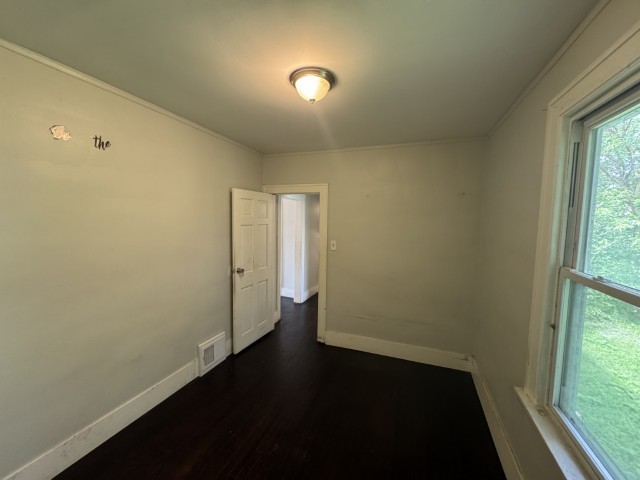 10117 South Perry Avenue Chicago, IL 60628 - Photo 17 of 33 an empty room with wooden floor and windows