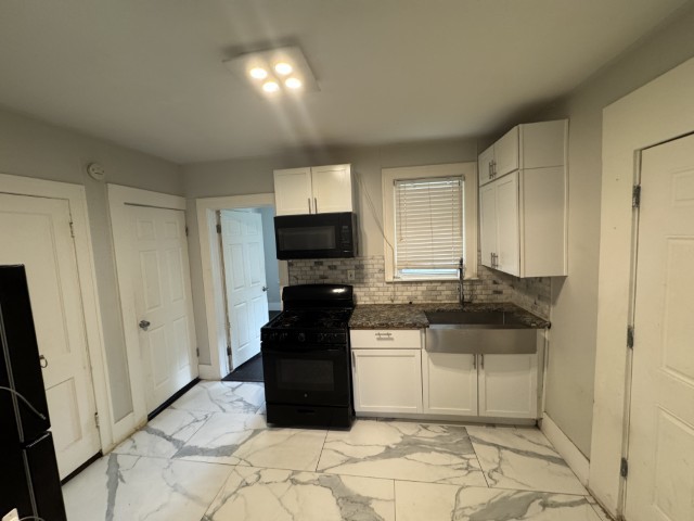 10117 South Perry Avenue Chicago, IL 60628 - Photo 19 of 33 a kitchen with granite countertop a sink and a stove top oven