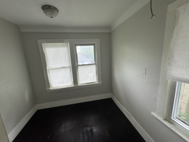 10117 South Perry Avenue Chicago, IL 60628 - Photo 23 of 33 an empty room with wooden floor and windows