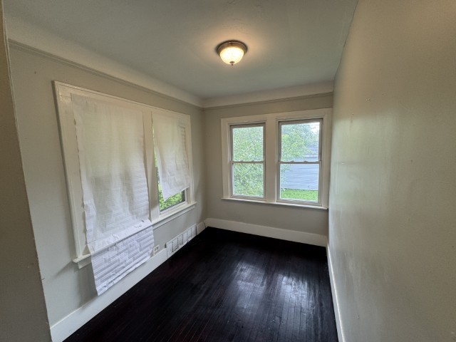 10117 South Perry Avenue Chicago, IL 60628 - Photo 27 of 33 an empty room with wooden floor and windows