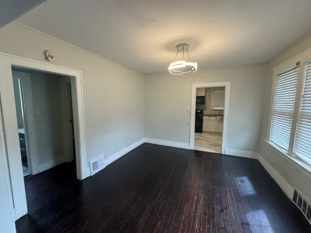 an empty room with wooden floor and window