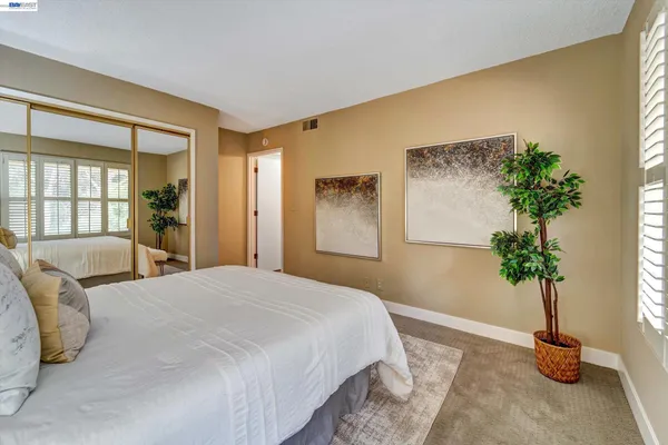 a bedroom with a bed and a potted plant