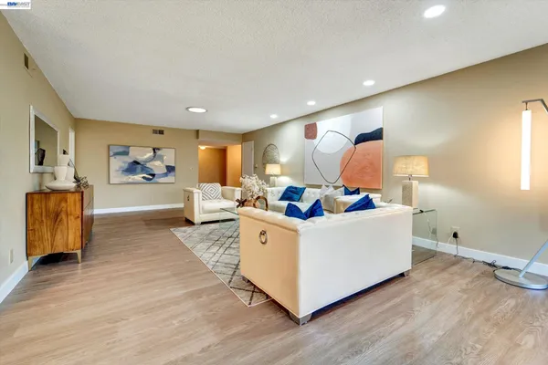 a living room with furniture and a wooden floor