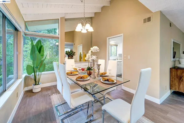 a dining room with furniture a large window and wooden floor