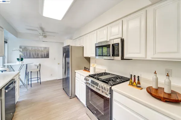 a kitchen with stainless steel appliances granite countertop a stove a sink and a refrigerator
