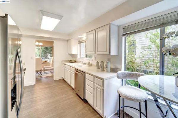 a large white kitchen with a window and stainless steel appliances