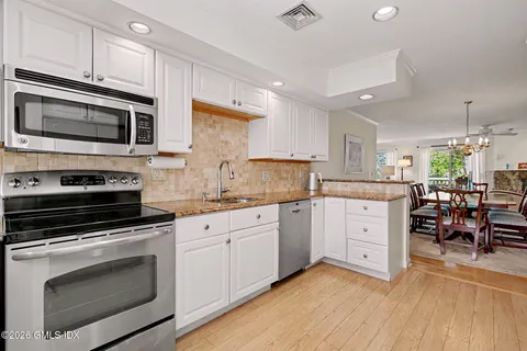 a kitchen with granite countertop cabinets stainless steel appliances and a wooden floor