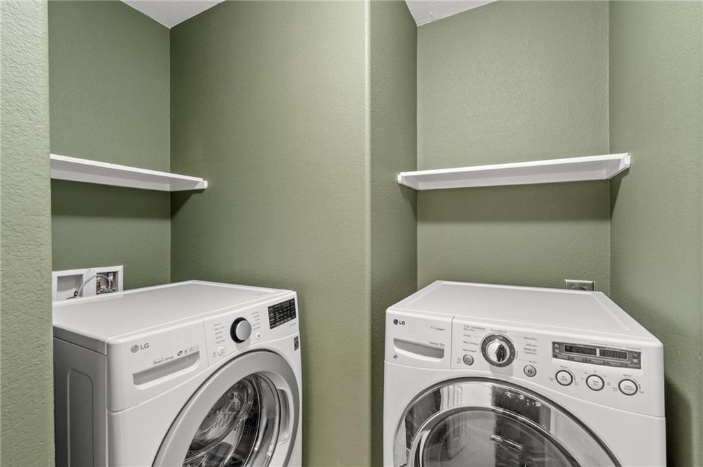 20224 Merlin Falcon Trail Pflugerville, TX 78660 - Photo 34 of 40 A dedicated laundry space, equipped for efficiency with a washer and dryer and convenient shelving.