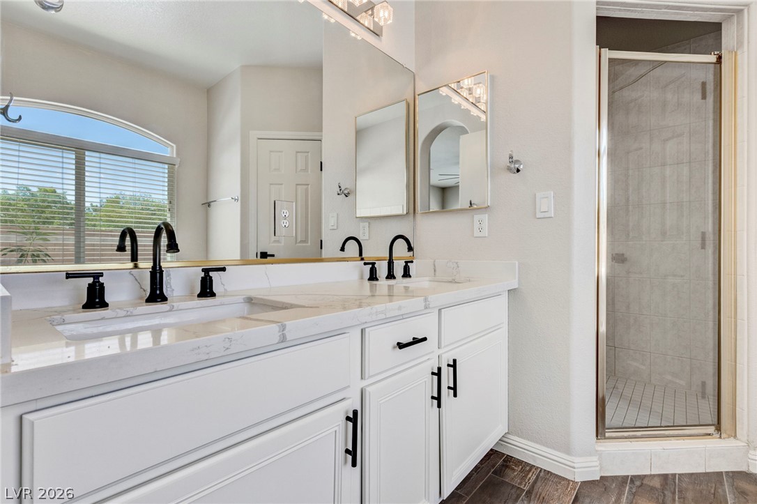 740 Aldo Rae Court, Unit NONE Henderson, NV 89052 - Photo 25 of 35 Dual vanities with sleek black fixtures and a glass-enclosed shower create a clean, contemporary feel.