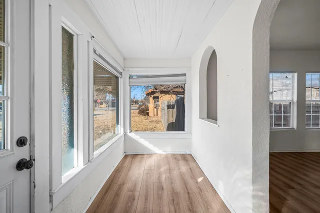 a view of a hallway with wooden floor and a living room
