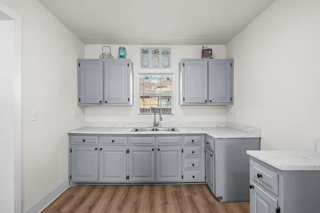 a kitchen with a sink cabinets and wooden floor