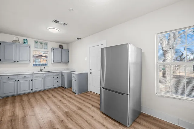 a kitchen with a refrigerator sink and cabinets