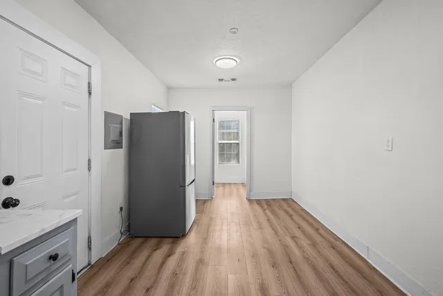a view of a kitchen with wooden floor and electronic appliances