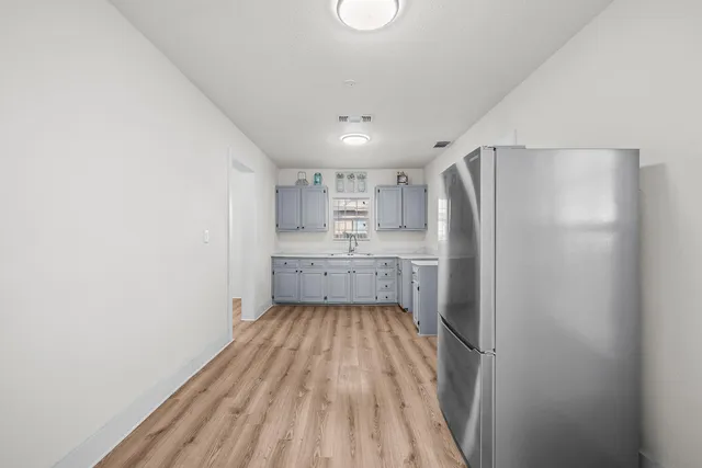 a view of a kitchen with a sink and wooden floor
