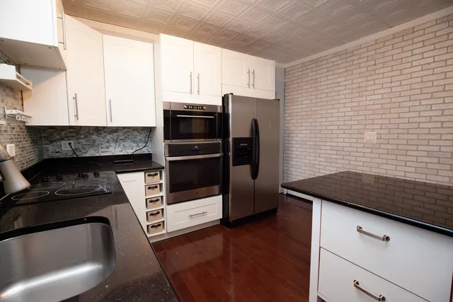 a kitchen with granite countertop a refrigerator and a stove