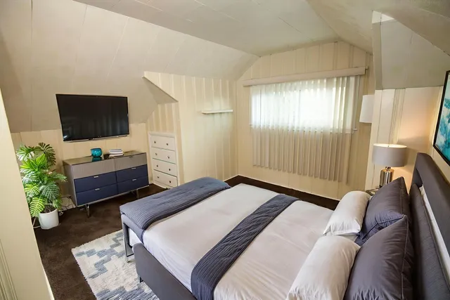 a bedroom with a bed and a flat screen tv