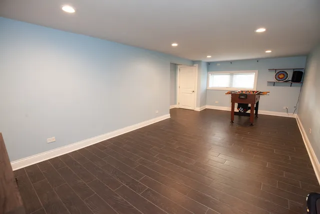 an empty room with wooden floor and a table